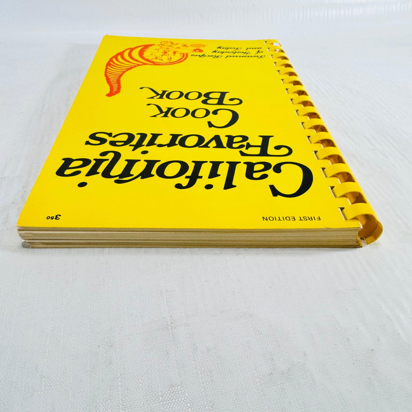 Close view of the yellow comb binding and the printed 350 cover price