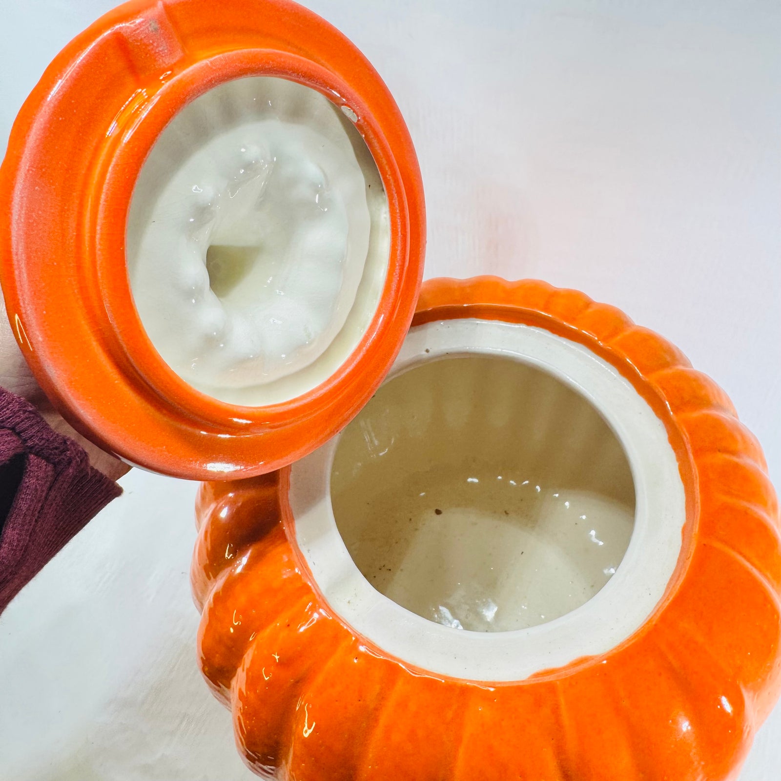 Ceramic pumpkin jar with lid off, showing the cream glazed interior