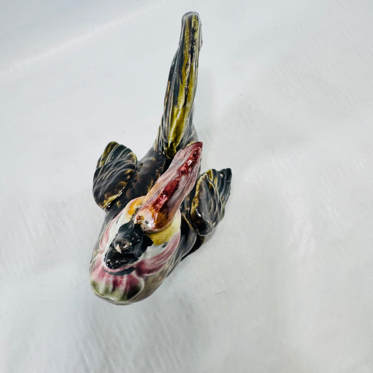 Top view of the ceramic rooster coin bank showing the comb, wings, and tail.