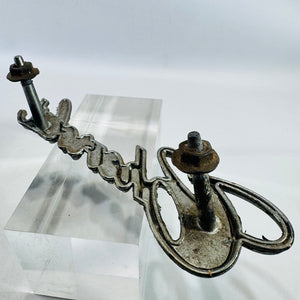 Angled rear view of Chevrolet 342389 grille emblem showing one angled mounting post