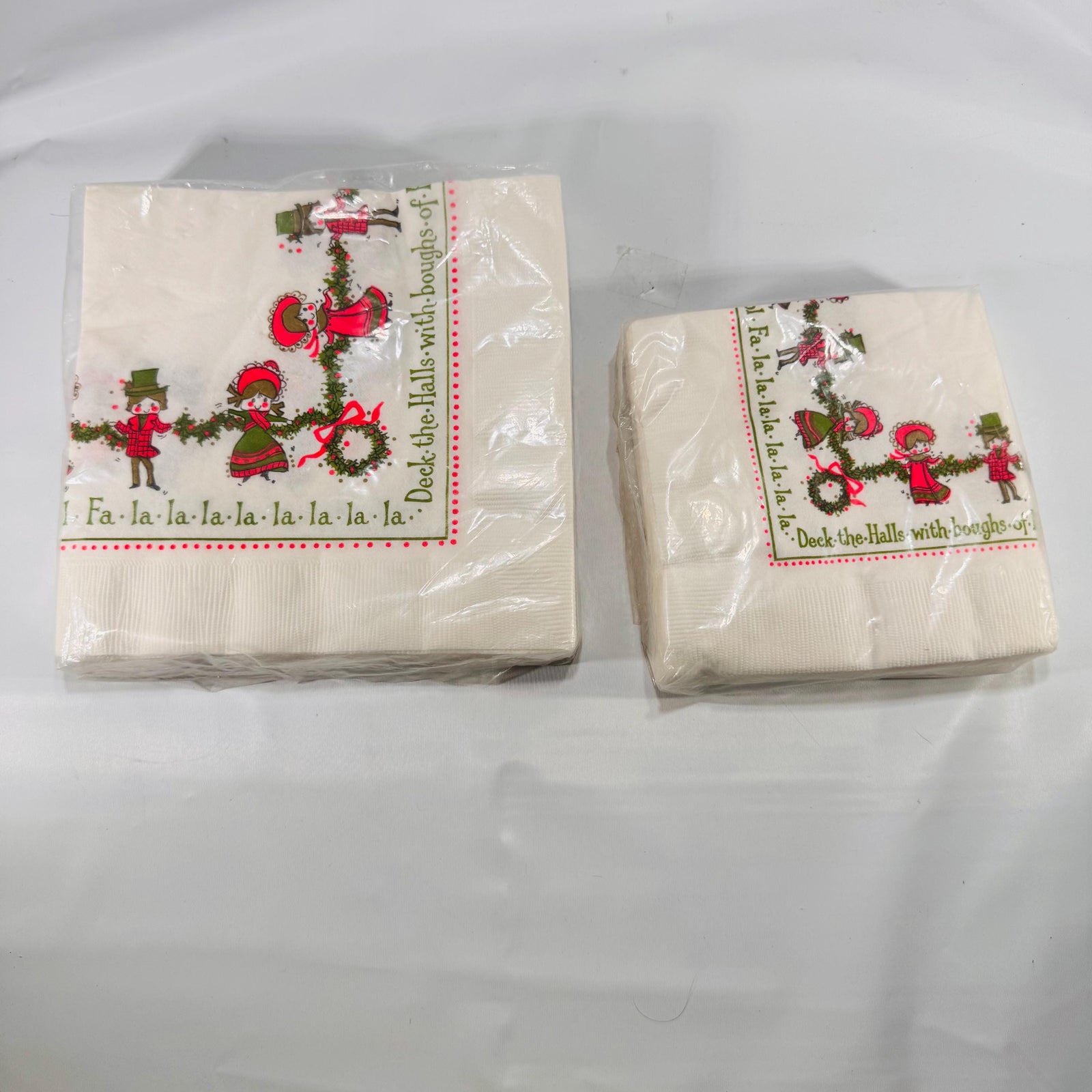 Front of sealed pack of 20 large Ambassador Christmas napkins featuring caroling children and holly garlands design