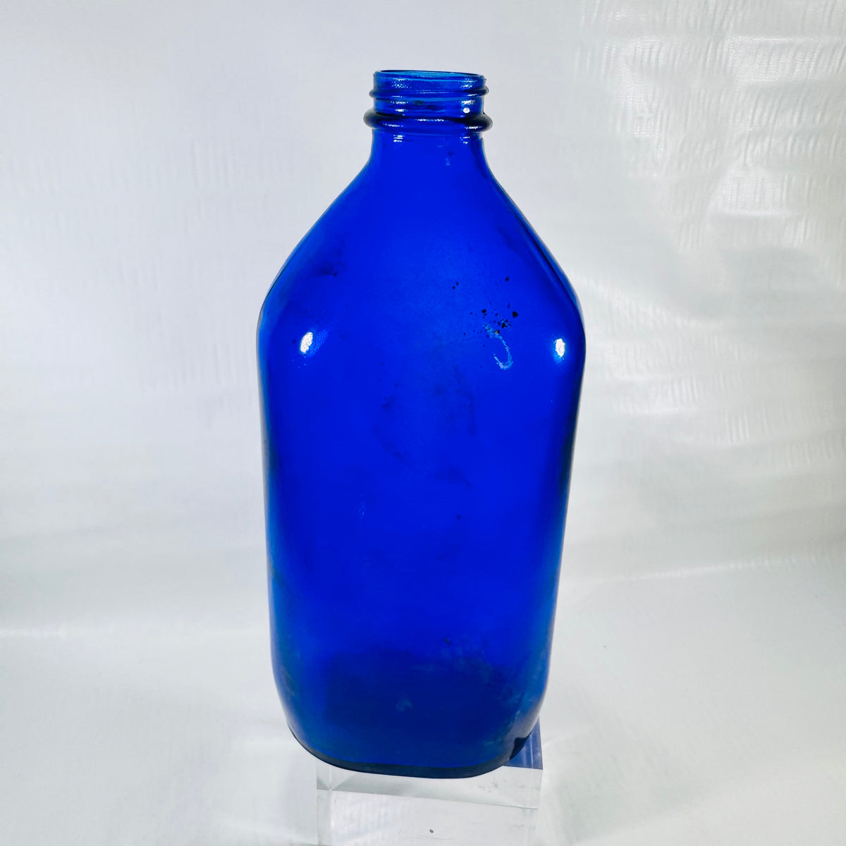 Front of a cobalt blue Genuine Phillips Milk of Magnesia bottle with a threaded screw top neck.
