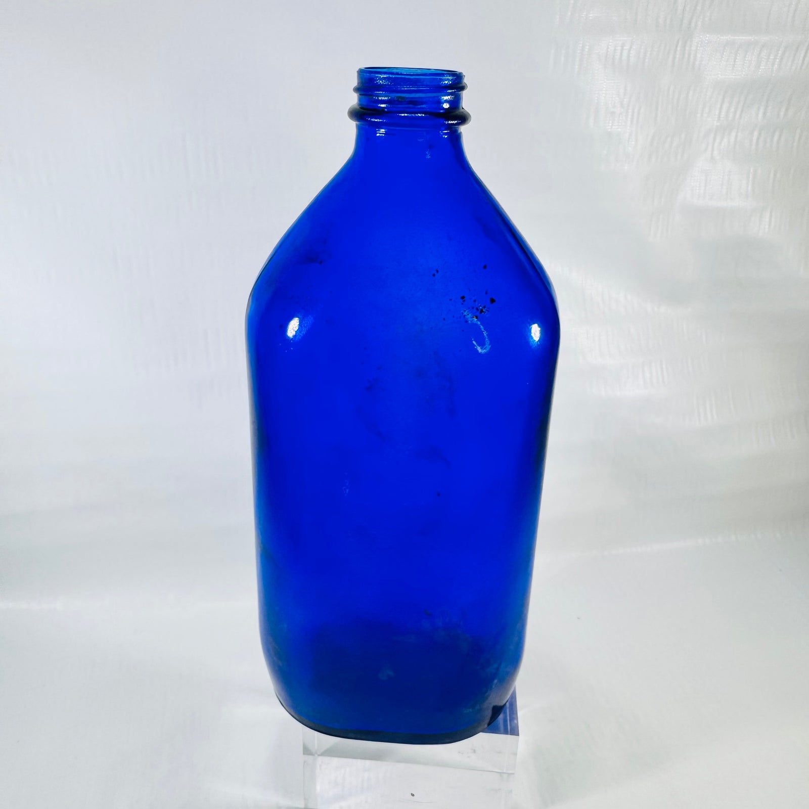 Front of a cobalt blue Genuine Phillips Milk of Magnesia bottle with a threaded screw top neck.