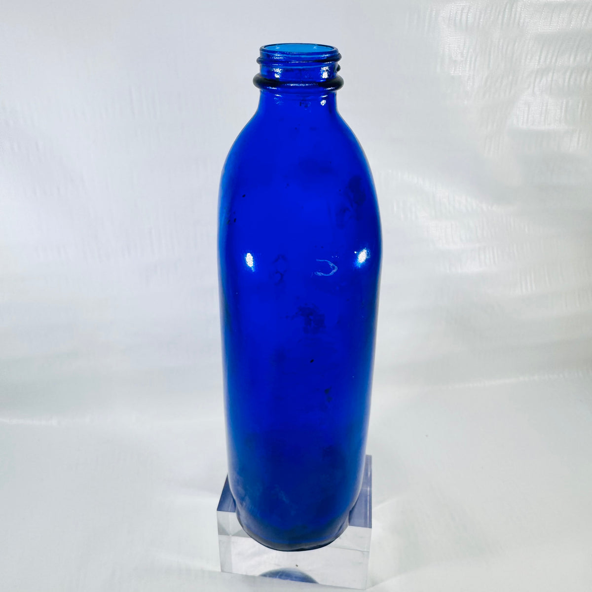 Side view of the cobalt blue Phillips bottle showing its rounded shape and residue inside.