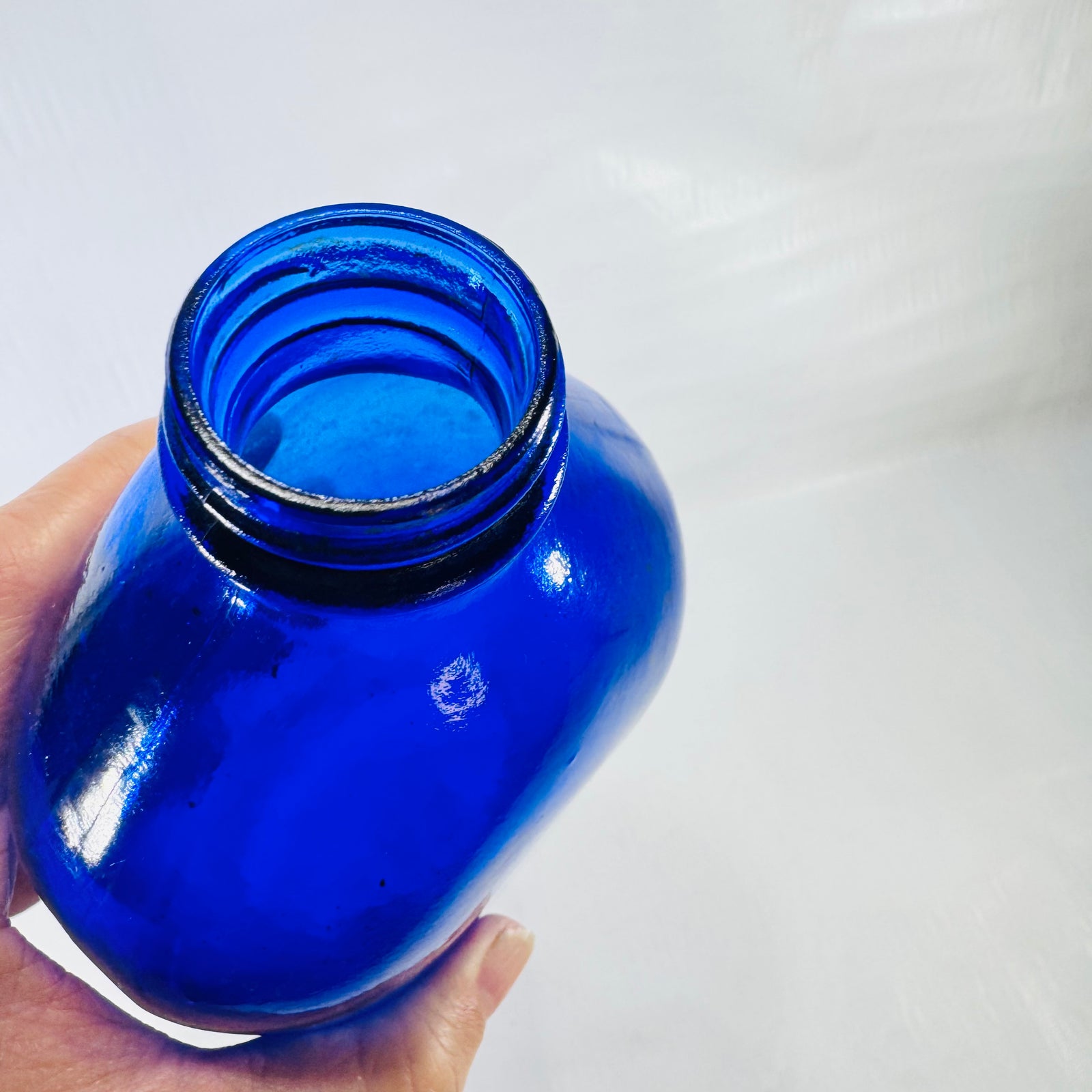 Top view of the threaded neck and smooth rim of the cobalt Phillips bottle.