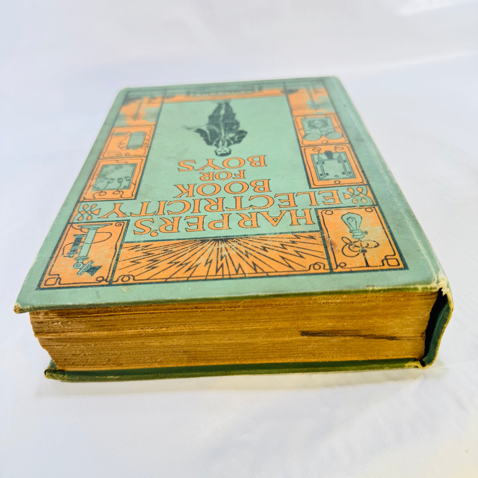 Angled top view of the 1907 Harper's book showing cover art and page edges