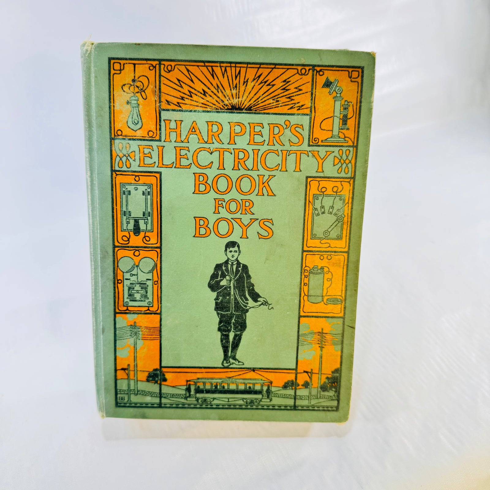 Harper's Electricity Book for Boys 1907 front cover, green pictorial cloth with boy holding wires