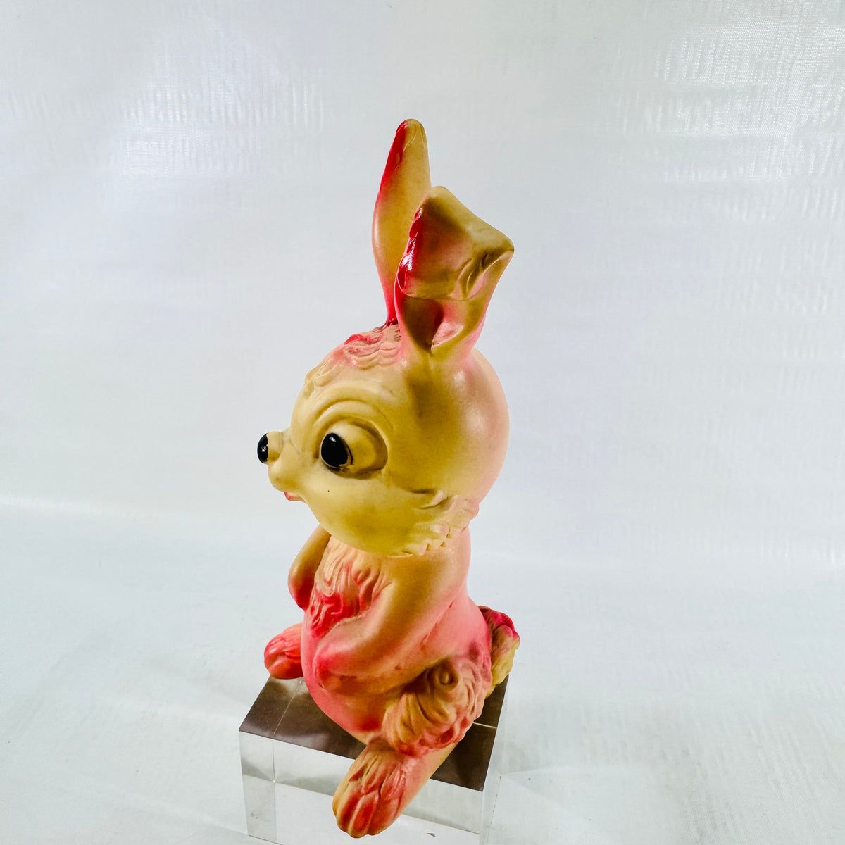 Three quarter view of the rabbit from its left side, showing the pink haunch, foot, and the ear tip folded over.