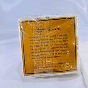 ack of cocktail napkin pack showing Ambassador branding, pricing code ‘50XNK 1H,’ and 20‐count label