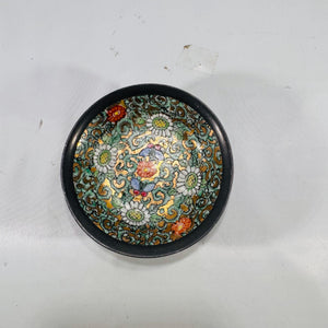 Top-down shot of interior of cloisonné bowl emphasizing scrolling turquoise vines, white daisies, red blooms, and golden accents.