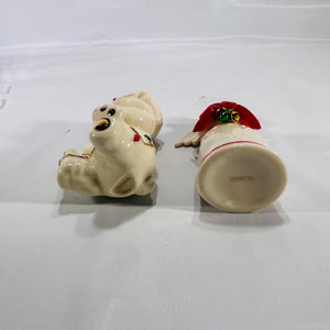 Bottom view of two Lenox® Christmas figurines: a 4″ porcelain angel marked ‘LENOX®’ and a 4″ porcelain teddy bear also marked ‘LENOX®,’ both with hand-painted holiday details and gold accents.