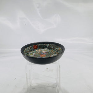 Front view of a small, round cloisonné bowl showing intricate floral enamel design in green, white, red, and gold.