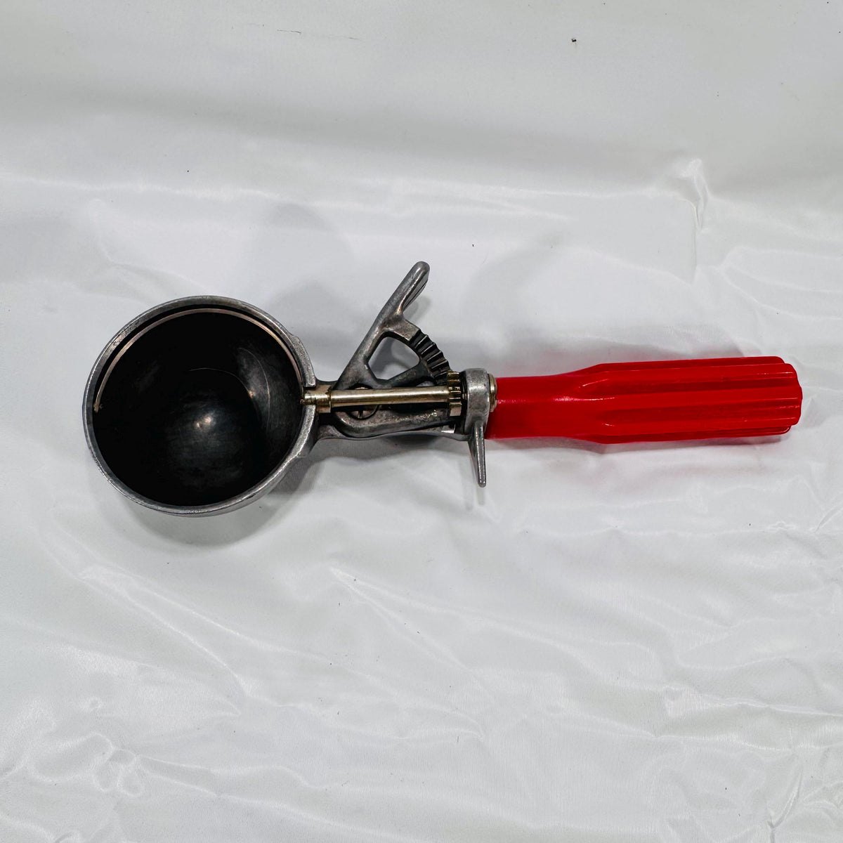 Overhead view of vintage red-handled ice cream scoop showing metal bowl