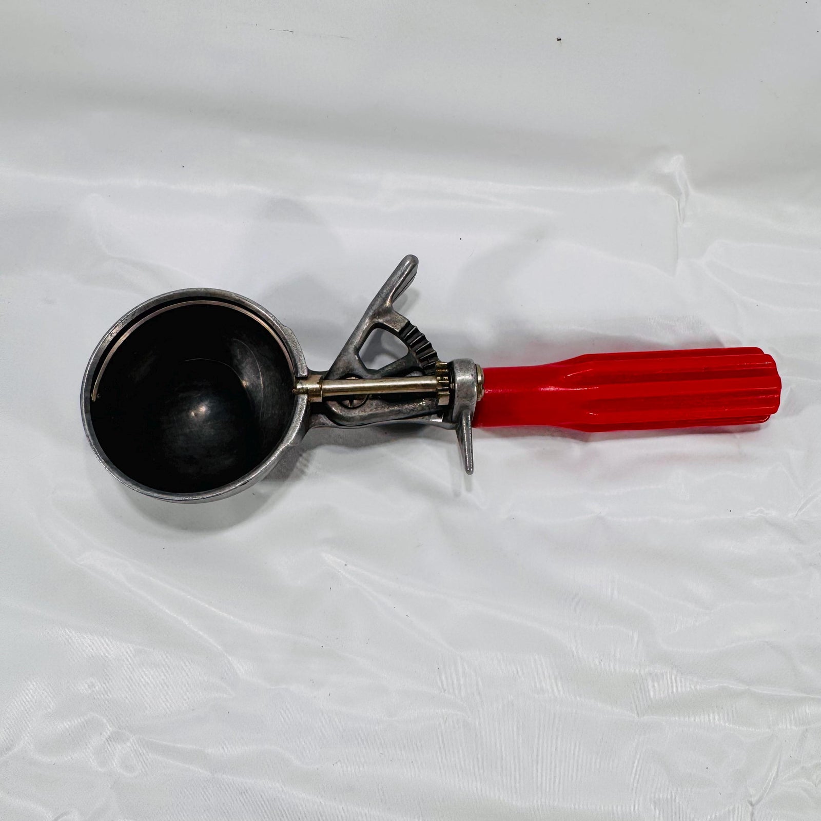 Overhead view of vintage red-handled ice cream scoop showing metal bowl