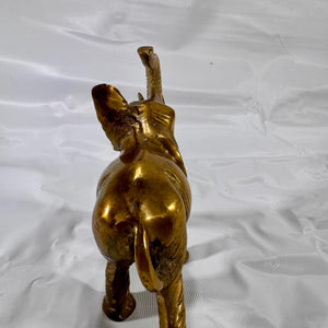 Back view of elephant figurine highlighting the curve of the back, tail, and hind legs.