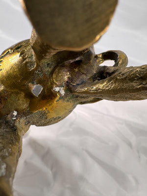 Underside close-up highlighting patina, wear marks, and casting details beneath the figurine.