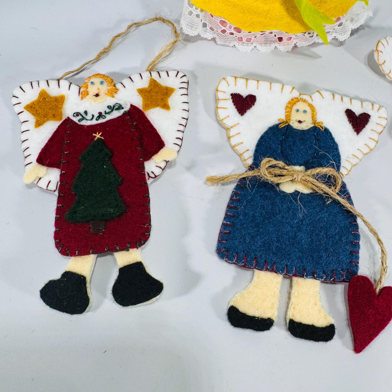Set of four handmade felt angel ornaments—three flat folk-art angels and one plush angel with lace trim and yarn hair, shown on a neutral background.