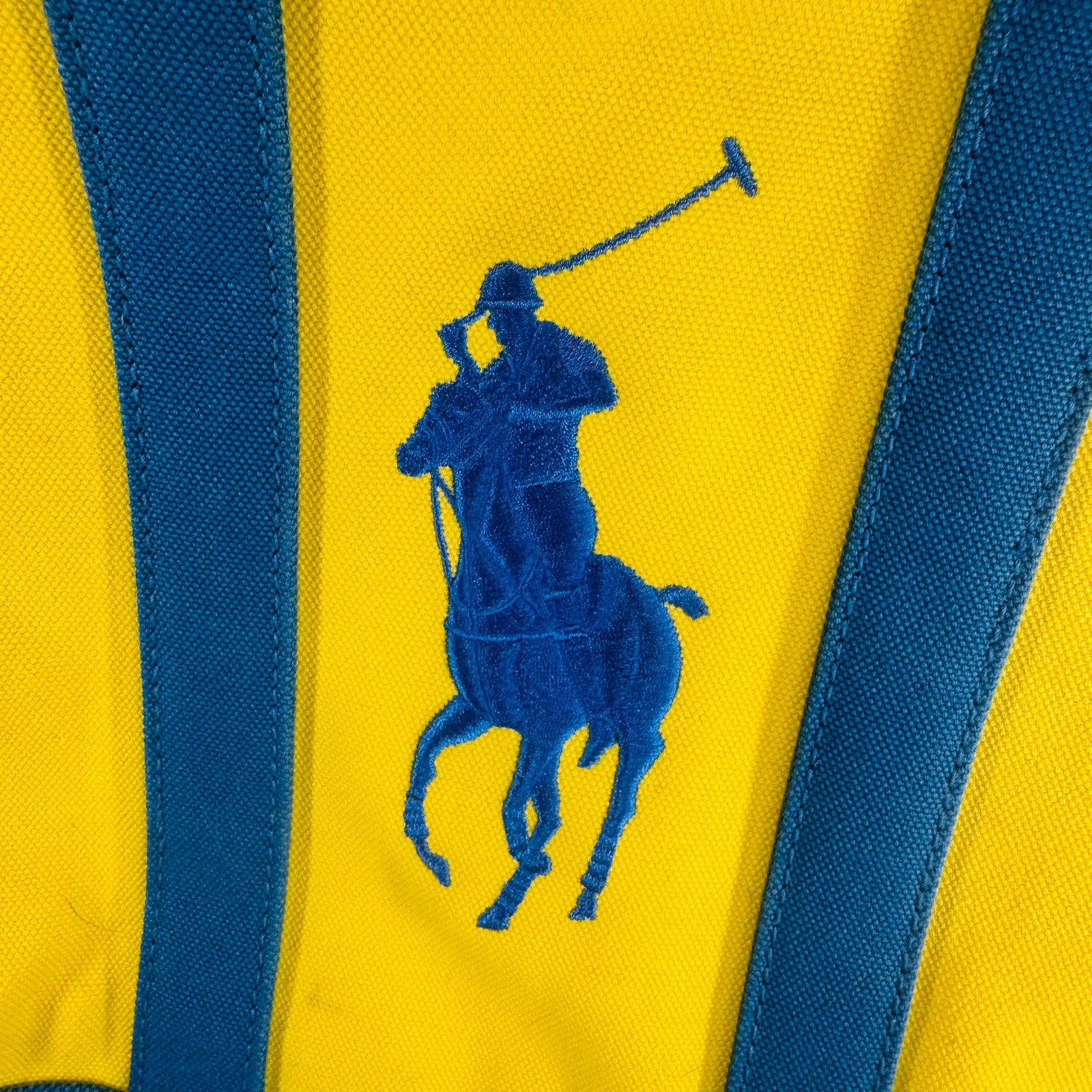 Bright yellow Ralph Lauren canvas tote with teal straps and oversized blue Big Pony logo, front view against light background.