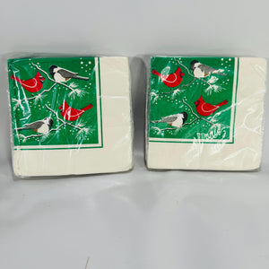 Two packs of vintage Wild Birds Unlimited Christmas napkins featuring red cardinals and chickadees on green pine branches with snowflakes.