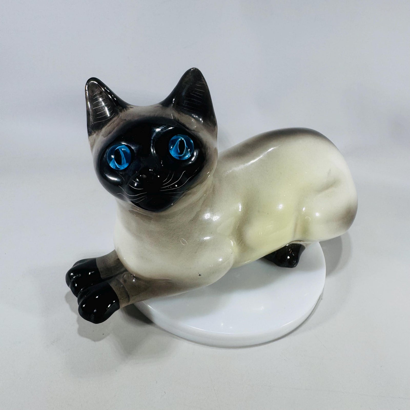 Vintage Italian Siamese cat figurine with blue glass eyes and shaded cream-to-black glaze, 8 inches long.