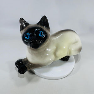 Vintage Italian Siamese cat figurine with blue glass eyes and shaded cream-to-black glaze, 8 inches long.
