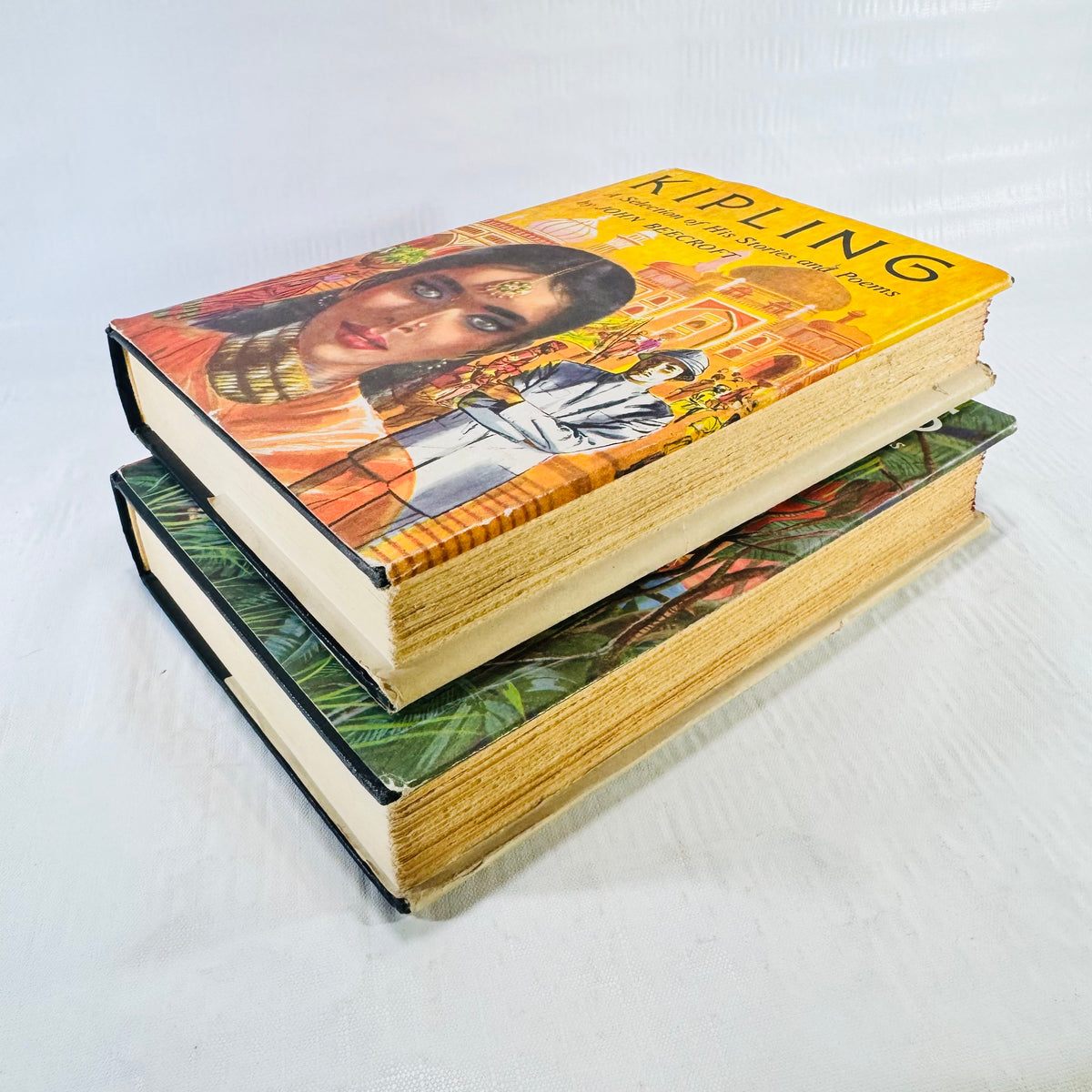 Two volumes stacked with the yellow Volume II jacket on top