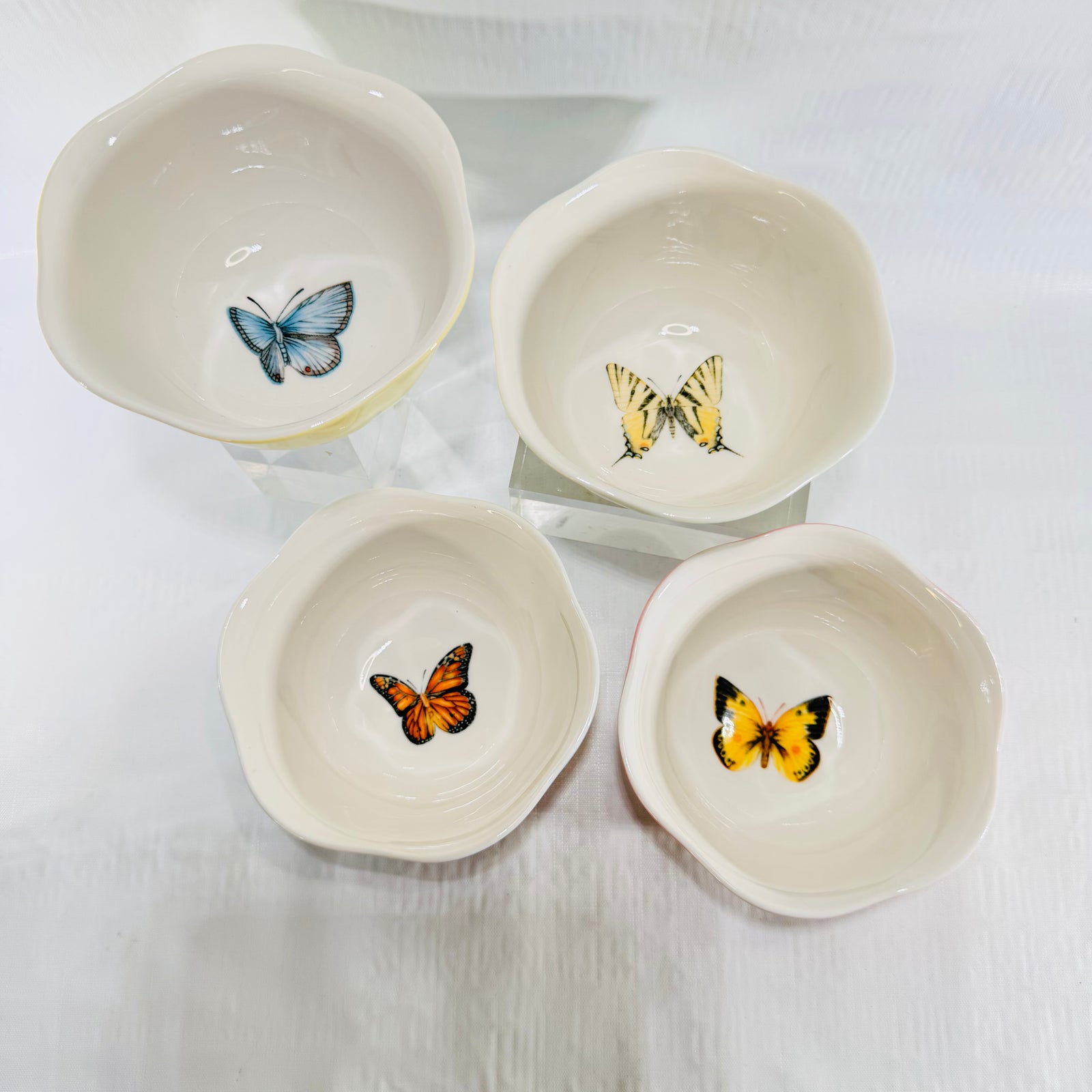 Stack of four Lenox Butterfly Meadow Colors bowls in yellow, pink, green and blue
