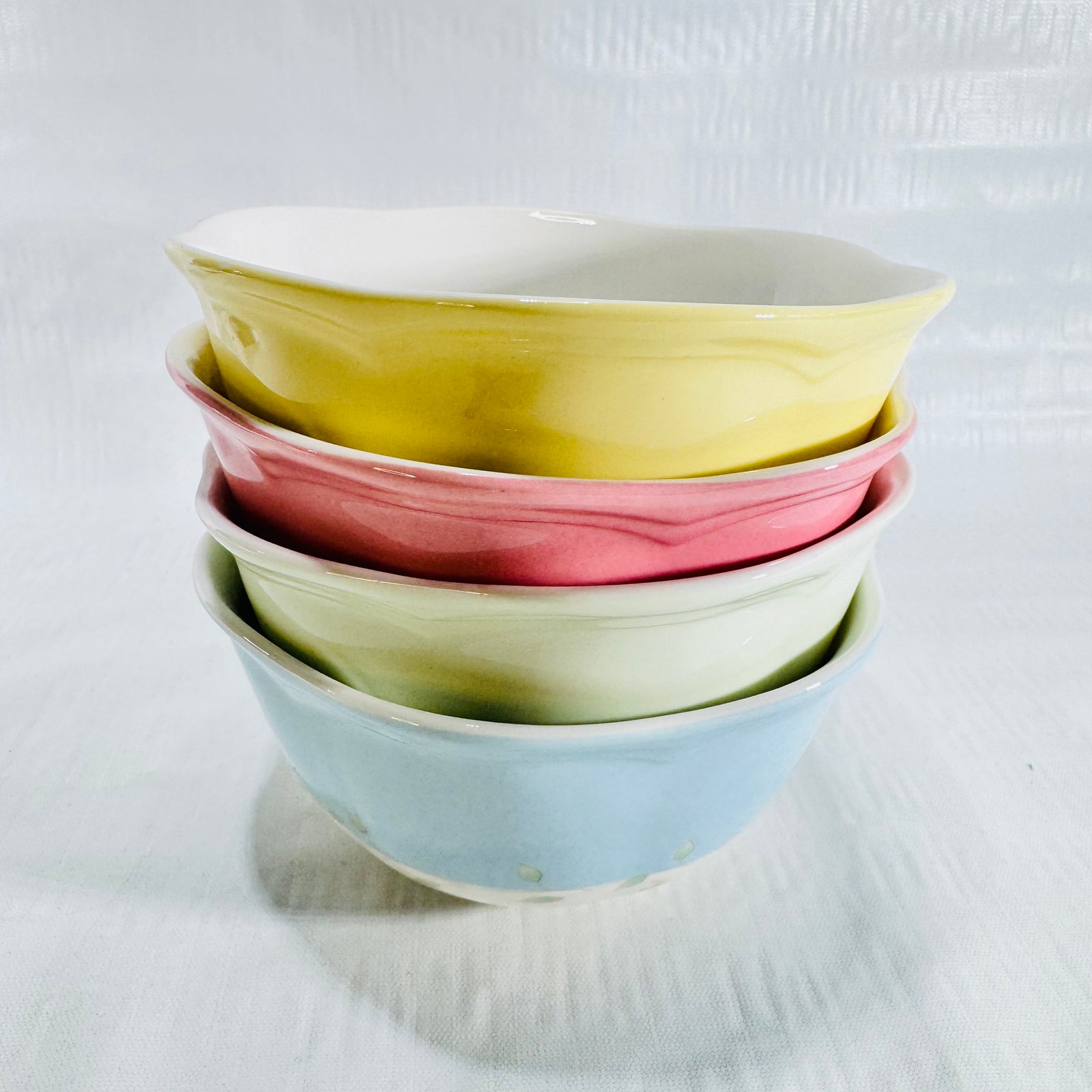 Stack of four Lenox Butterfly Meadow Colors bowls in yellow, pink, green and blue