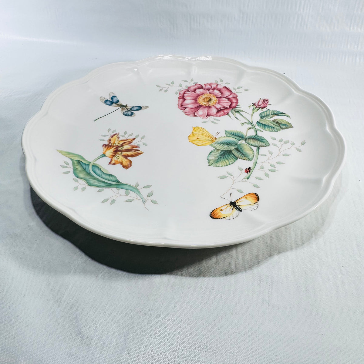 Three quarter view of the Lenox Butterfly Meadow Dragonfly 11 inch dinner plate with pink rose