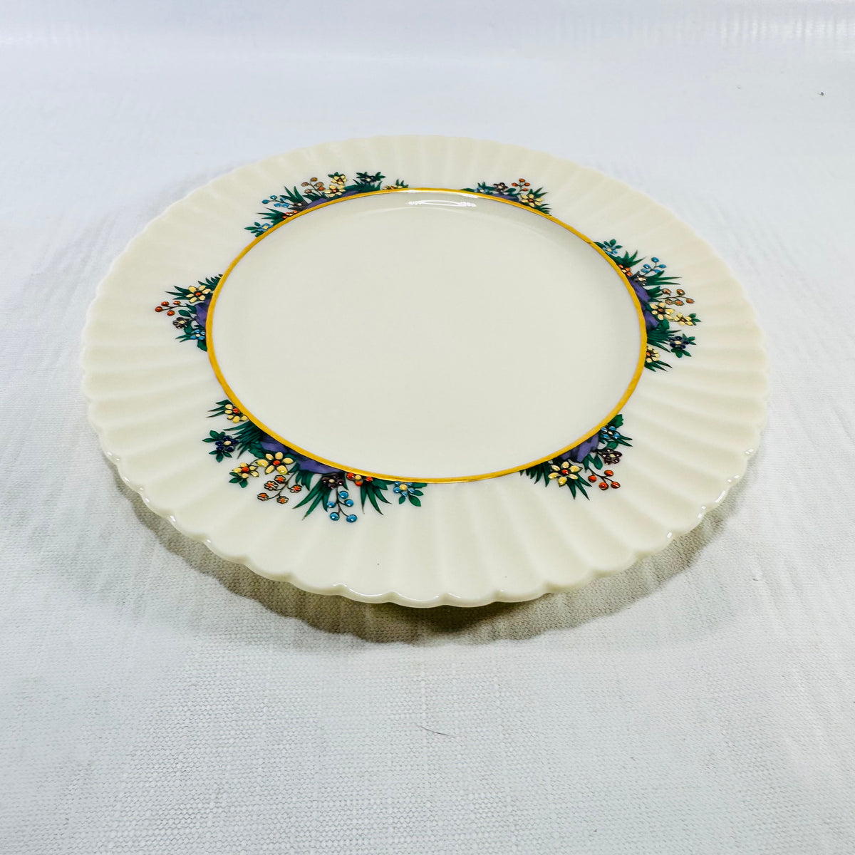 Overhead view of Lenox Rutledge bread and butter plate on white linen with four floral sprays