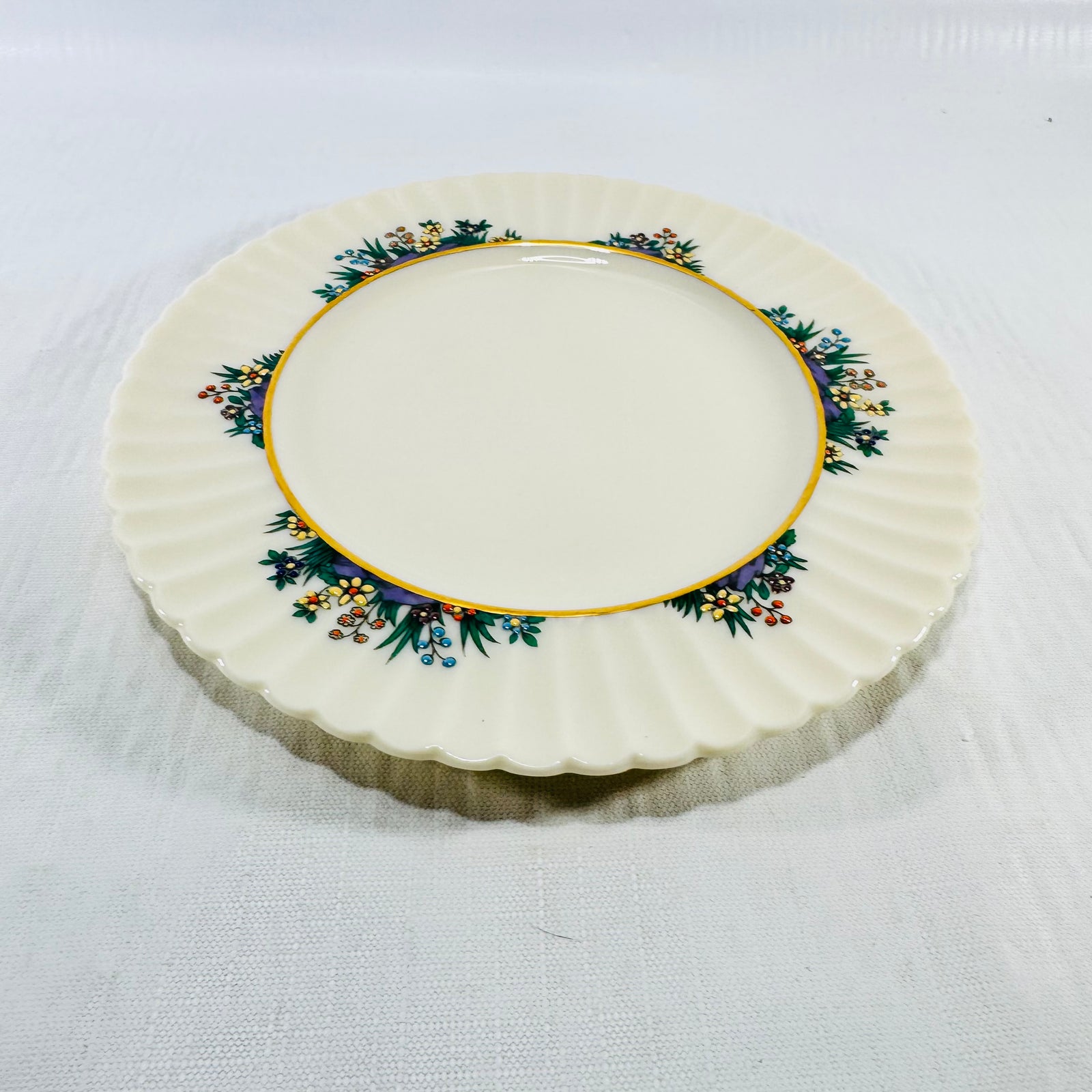 Overhead view of Lenox Rutledge bread and butter plate on white linen with four floral sprays