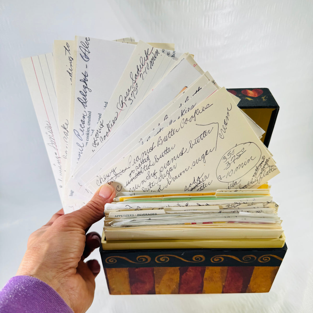 More handwritten recipe cards fanned out above the heart and stripe recipe box
