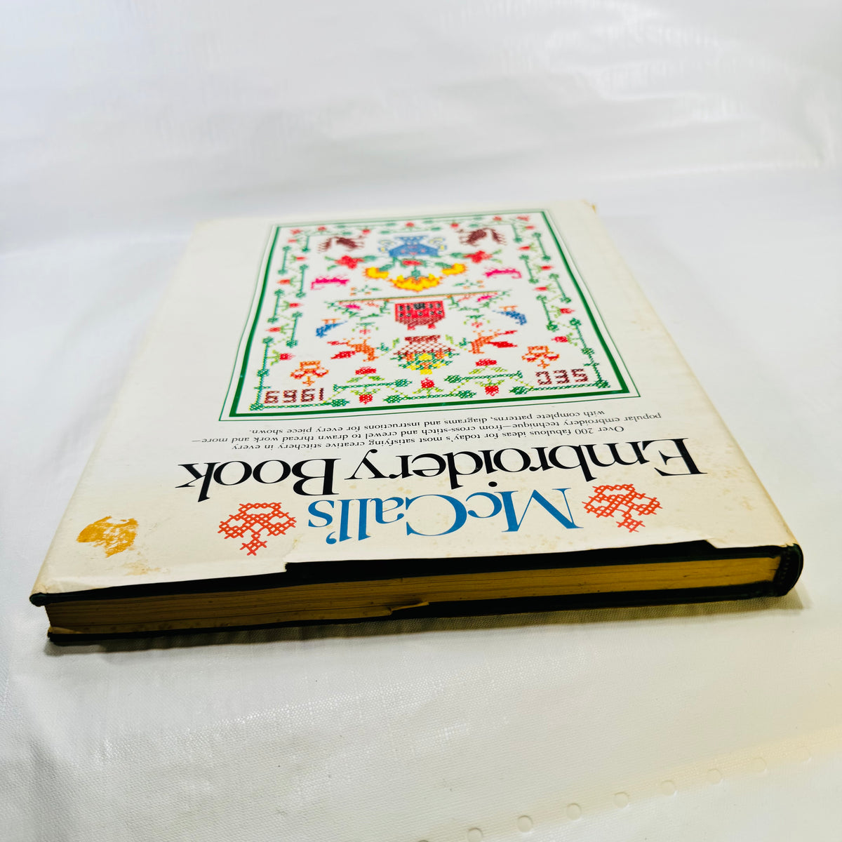 McCall's Embroidery Book top edge showing jacket chips and sticker residue