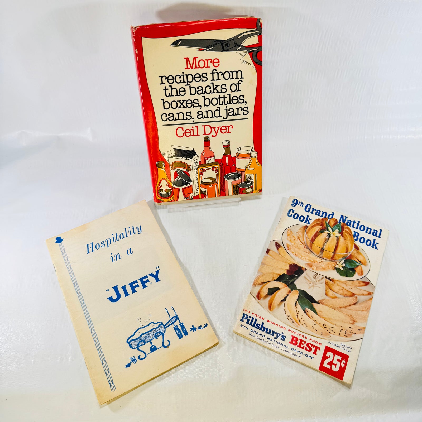 Three vintage cookbooks arranged in a triangle, Ceil Dyer, Jiffy and Pillsbury