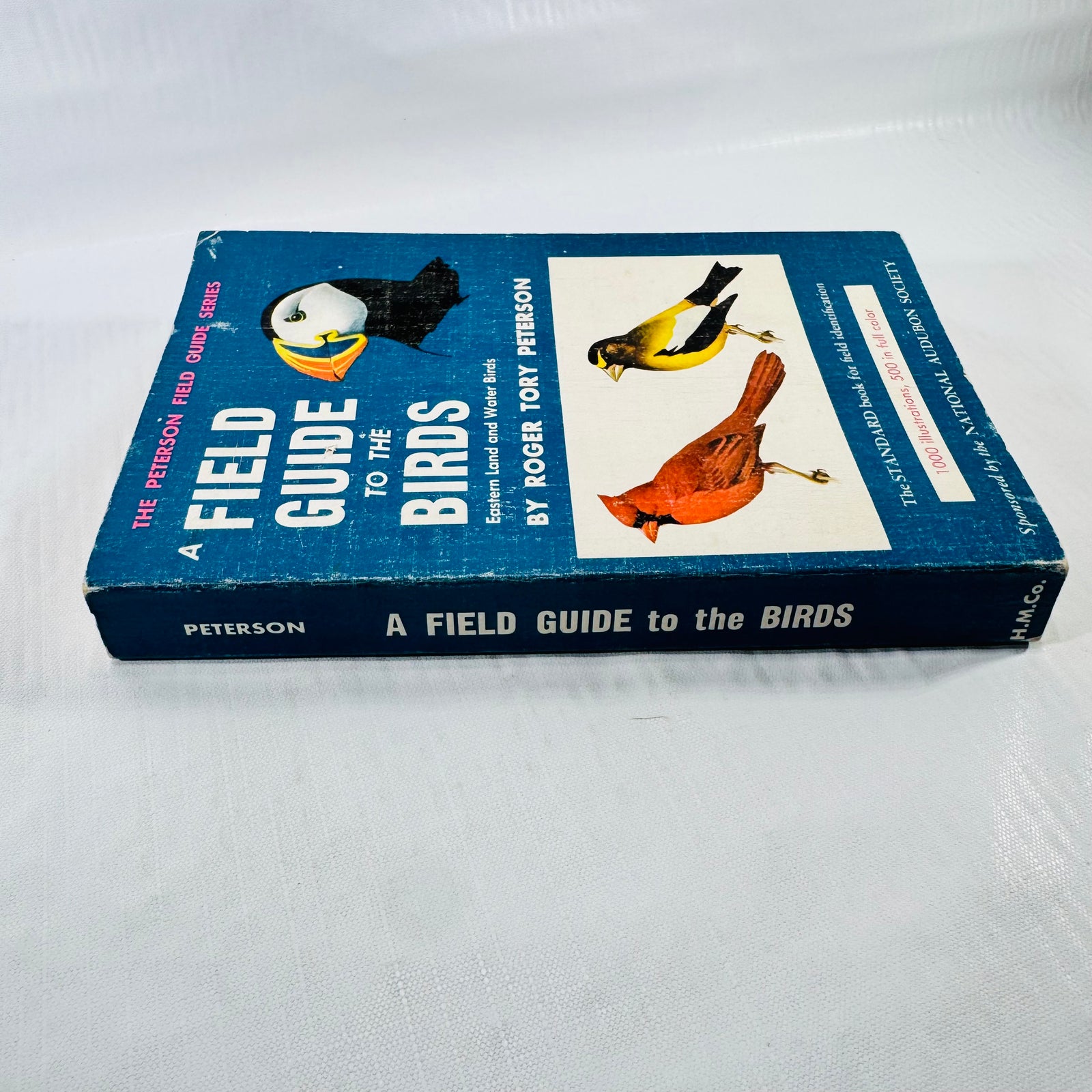 Peterson's A Field Guide to the Birds lying flat, showing the blue titled spine, illustrated front cover, and worn spine folds.