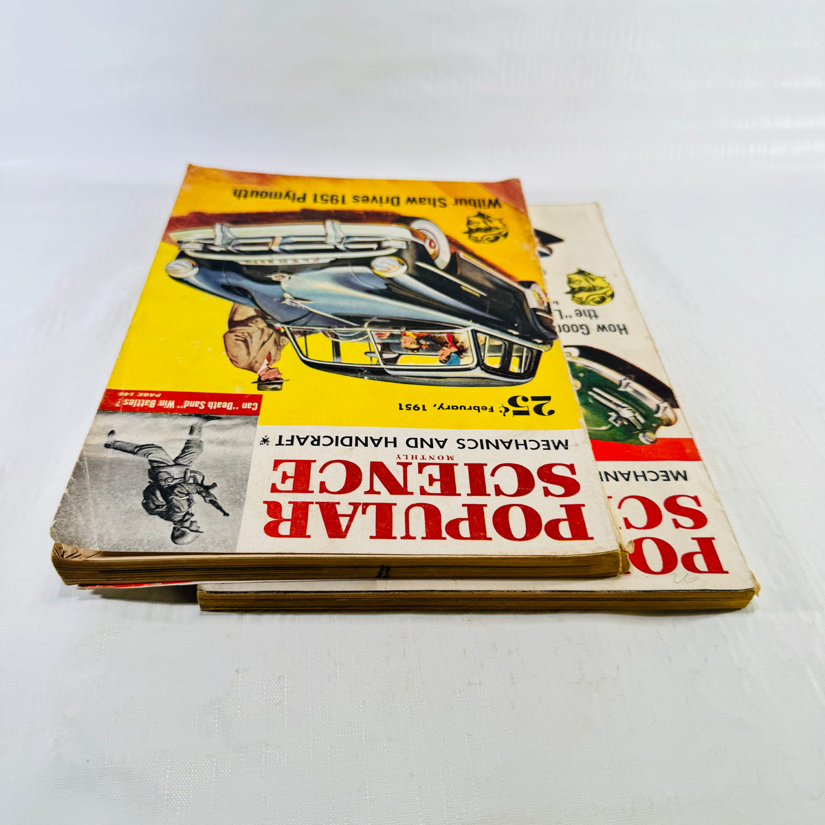 Overhead view of both 1951 Popular Science magazines stacked, February Plymouth cover on top