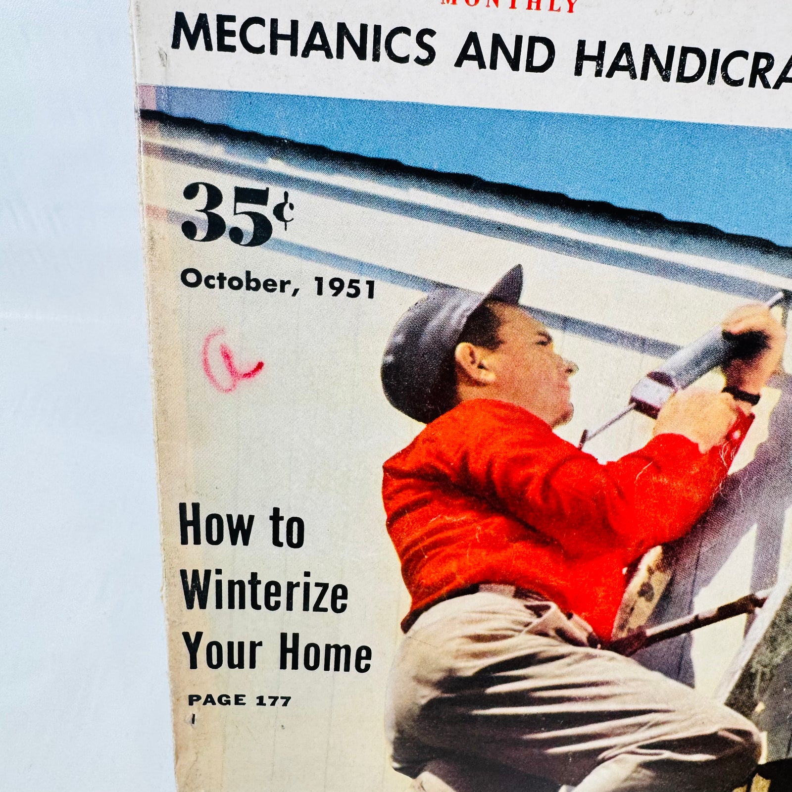October 1951 cover close up of man caulking a window, small red handwritten mark