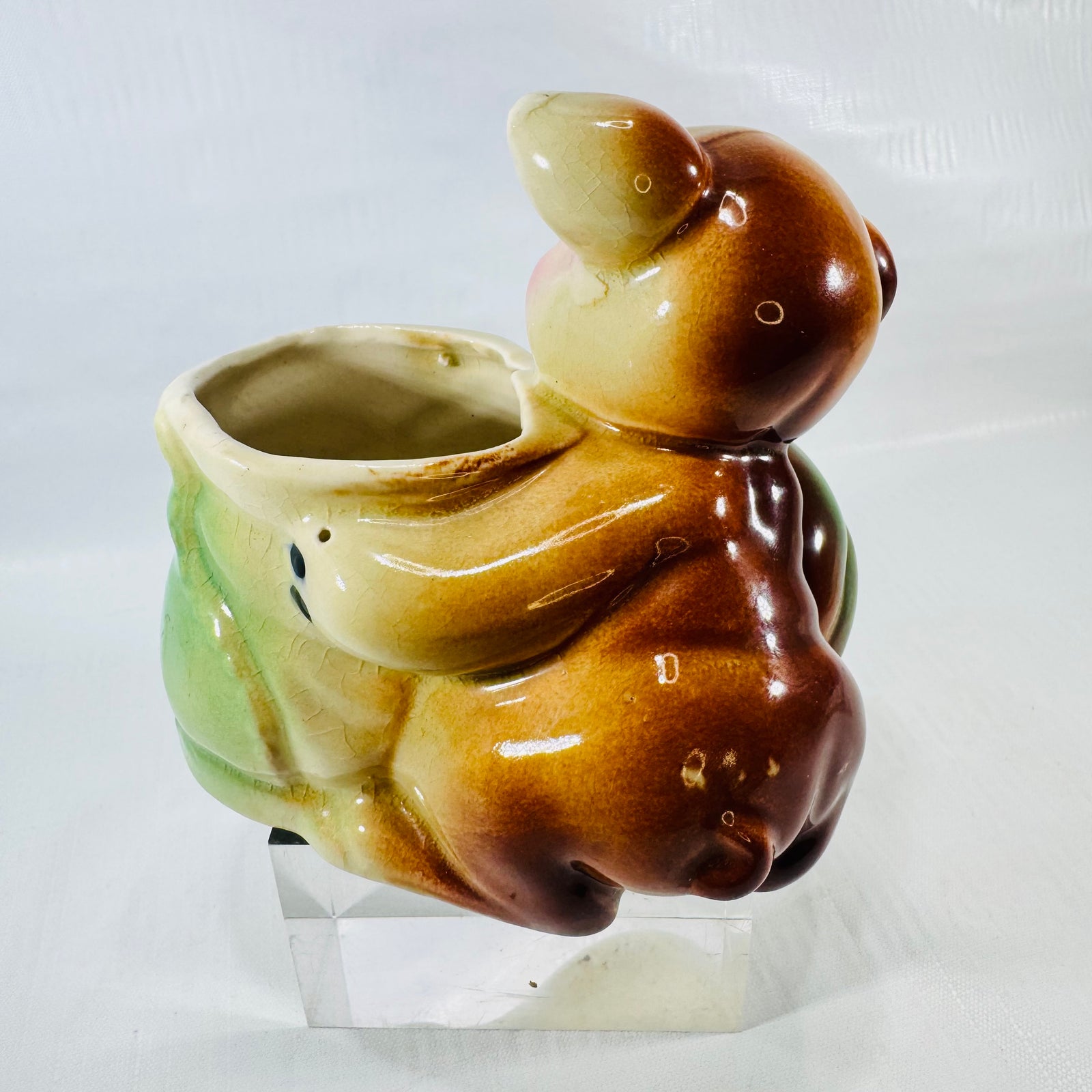 Side view of the puppy planter showing caramel and brown glaze on the puppy and the boot opening.