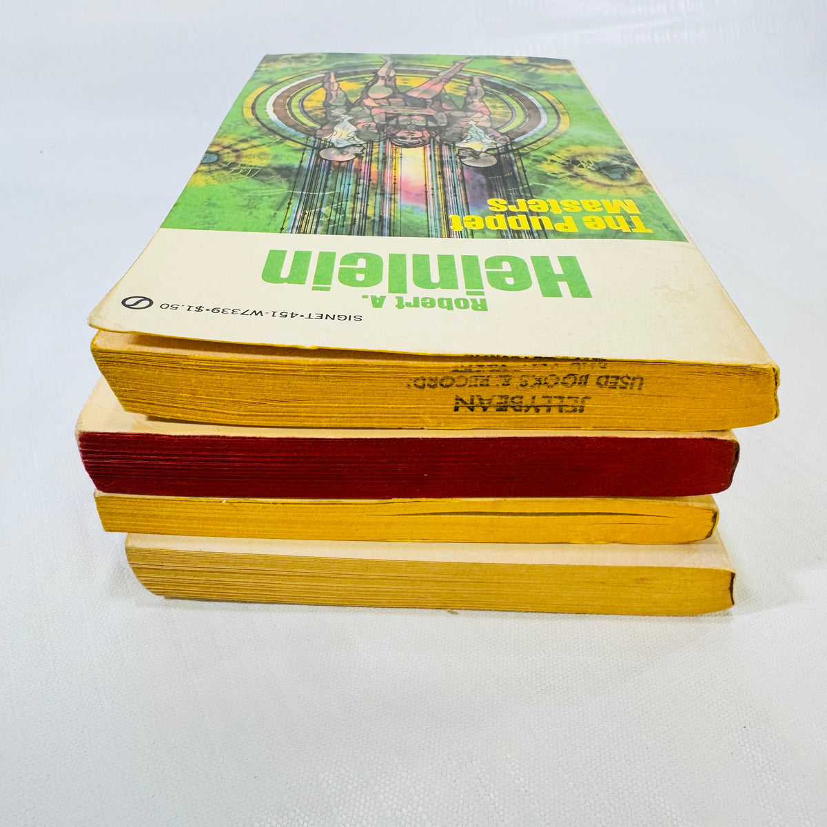 Page edges of the Heinlein paperbacks with a used bookstore stamp