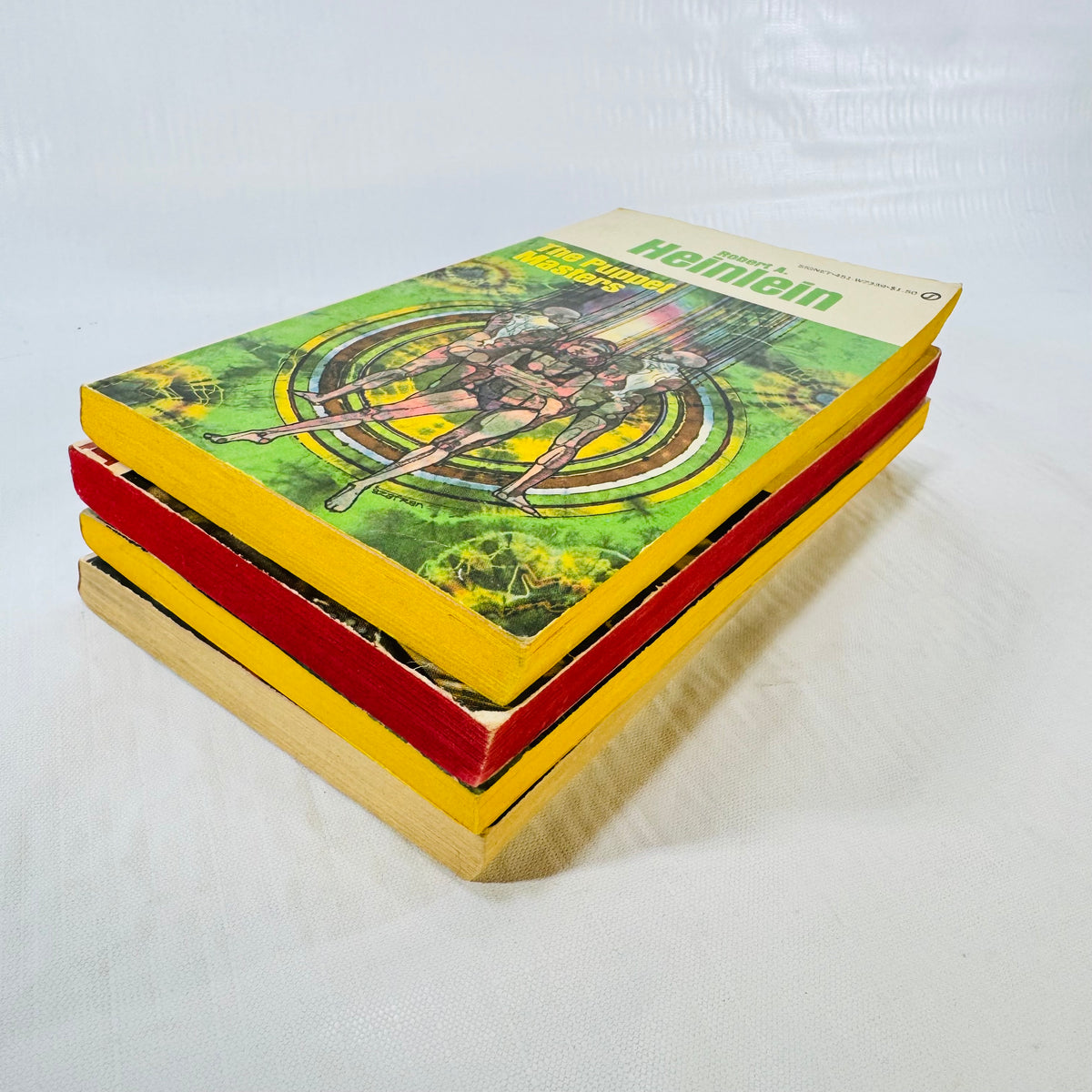 Angled stack of four vintage Heinlein Signet paperbacks