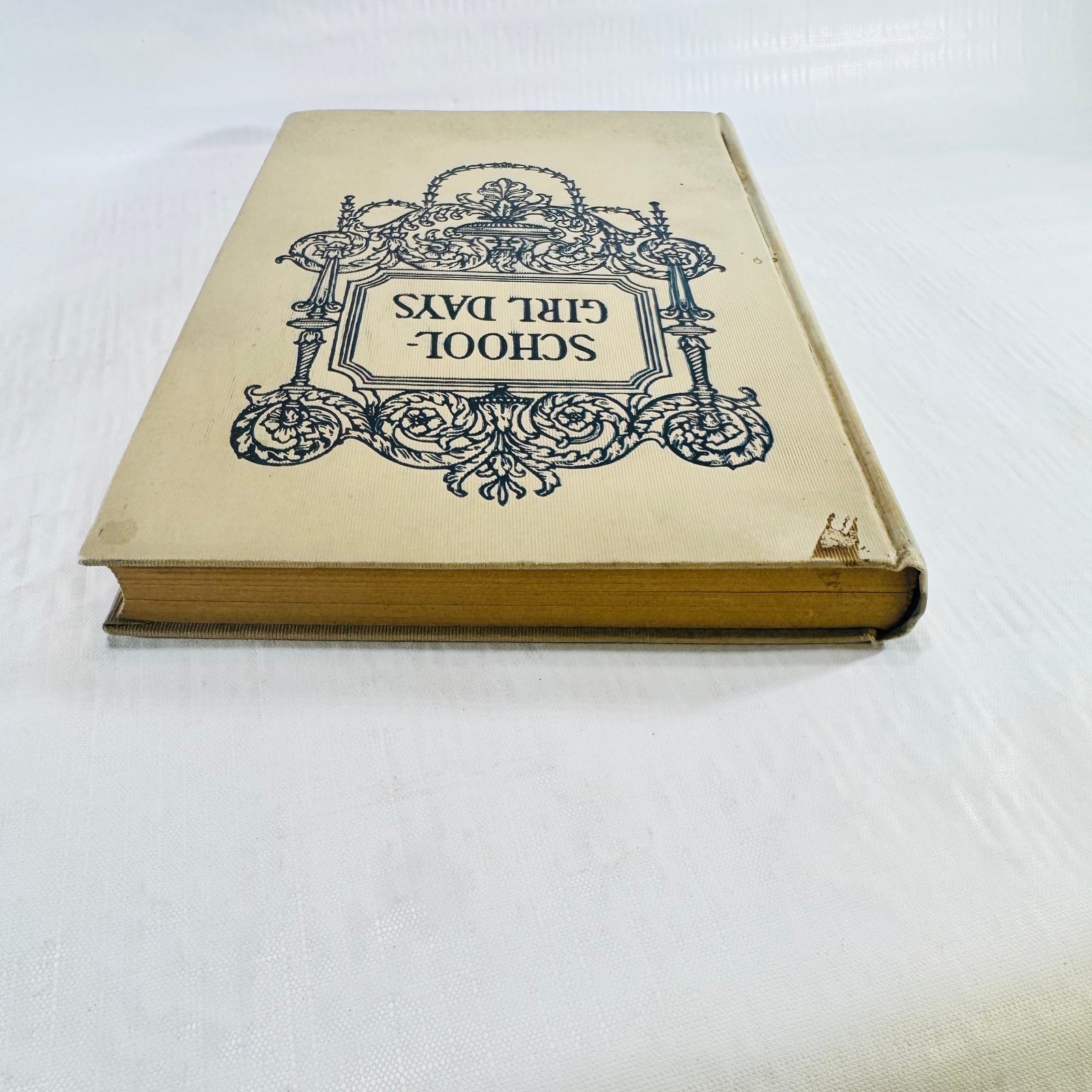 Cover turned upside down, showing cloth loss at a corner and tanned page edges