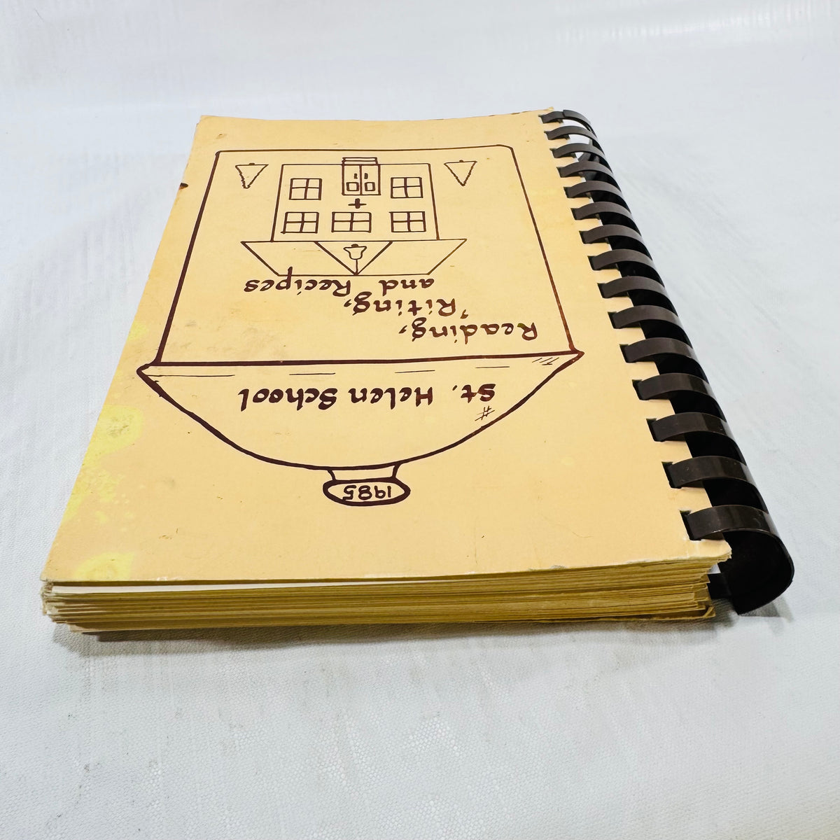 Page edges and front cover edge wear on the St. Helen School cookbook