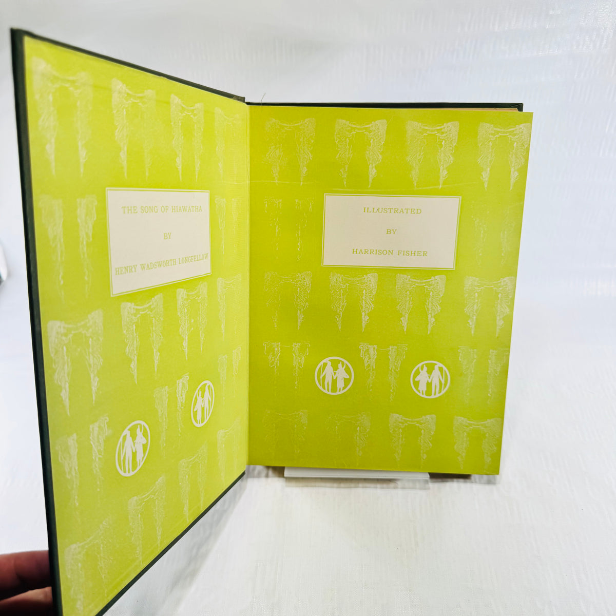 Green pictorial endpapers lettered The Song of Hiawatha by Longfellow, illustrated by Harrison Fisher
