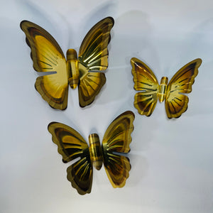 Set of three vintage Homco metal brass-tone butterfly wall art pieces in graduated sizes, shown front and back with hanging hardware and aged gold finish.