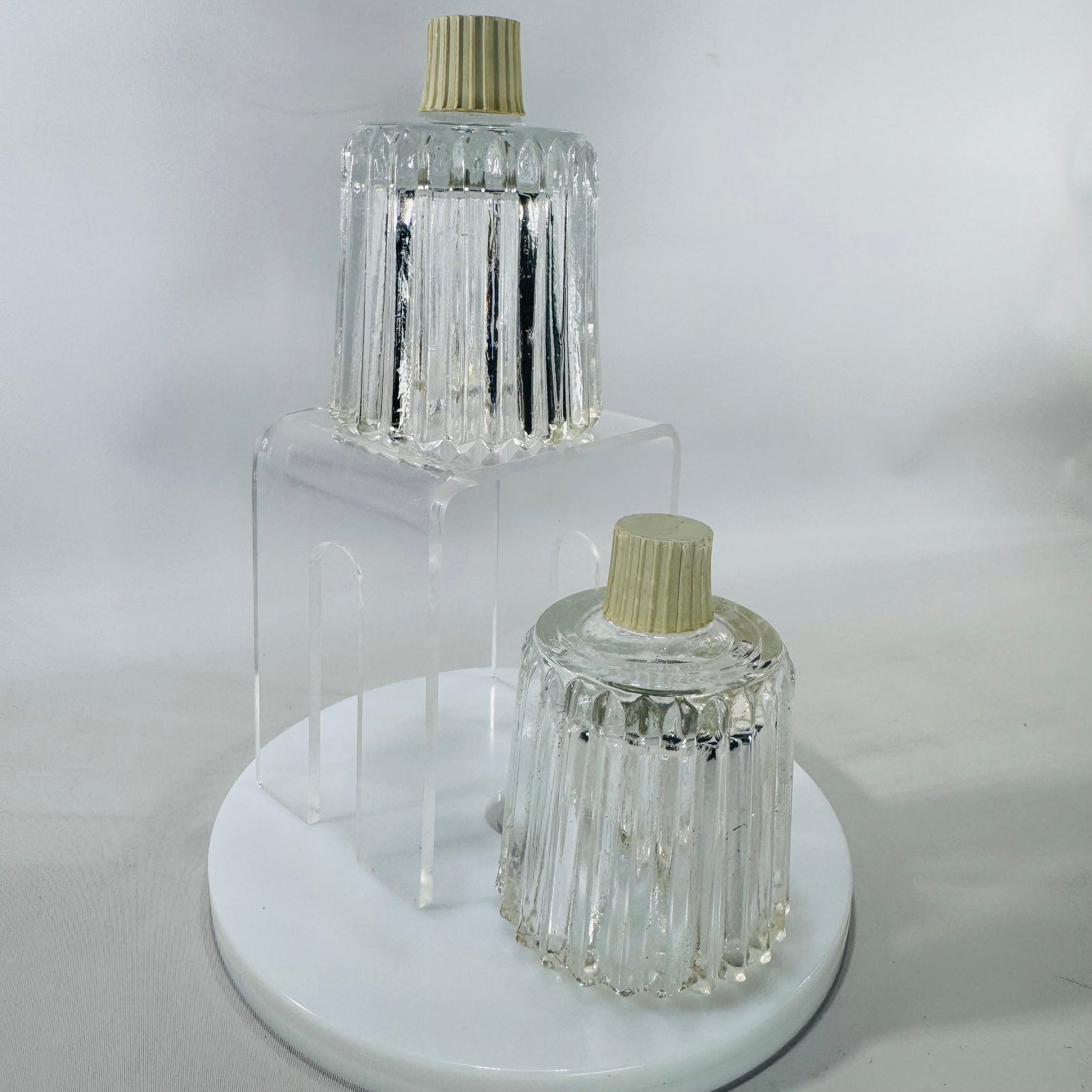  two vintage HOMCO Home Interiors clear ribbed glass peg votive cups with scalloped tulip rims, photographed on a white backdrop.