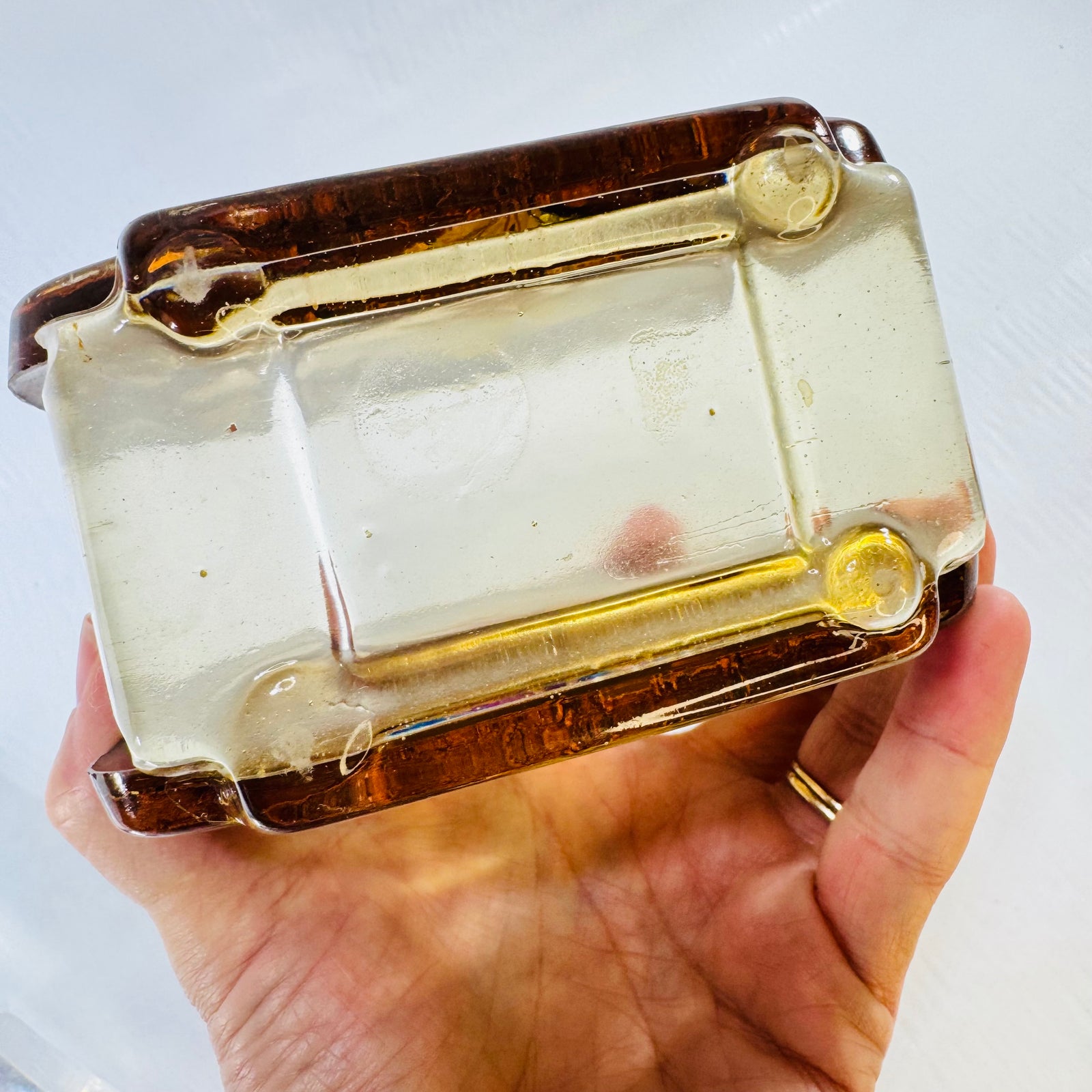 Underside of the lucite resin napkin holder base held in hand