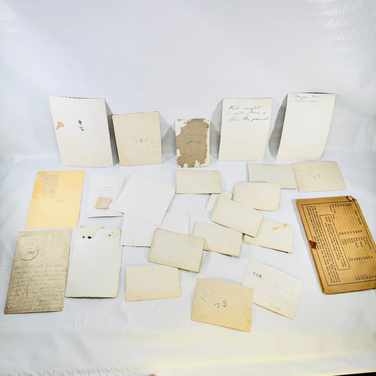 Backs of all pieces in the vintage snapshot lot with handwritten notes