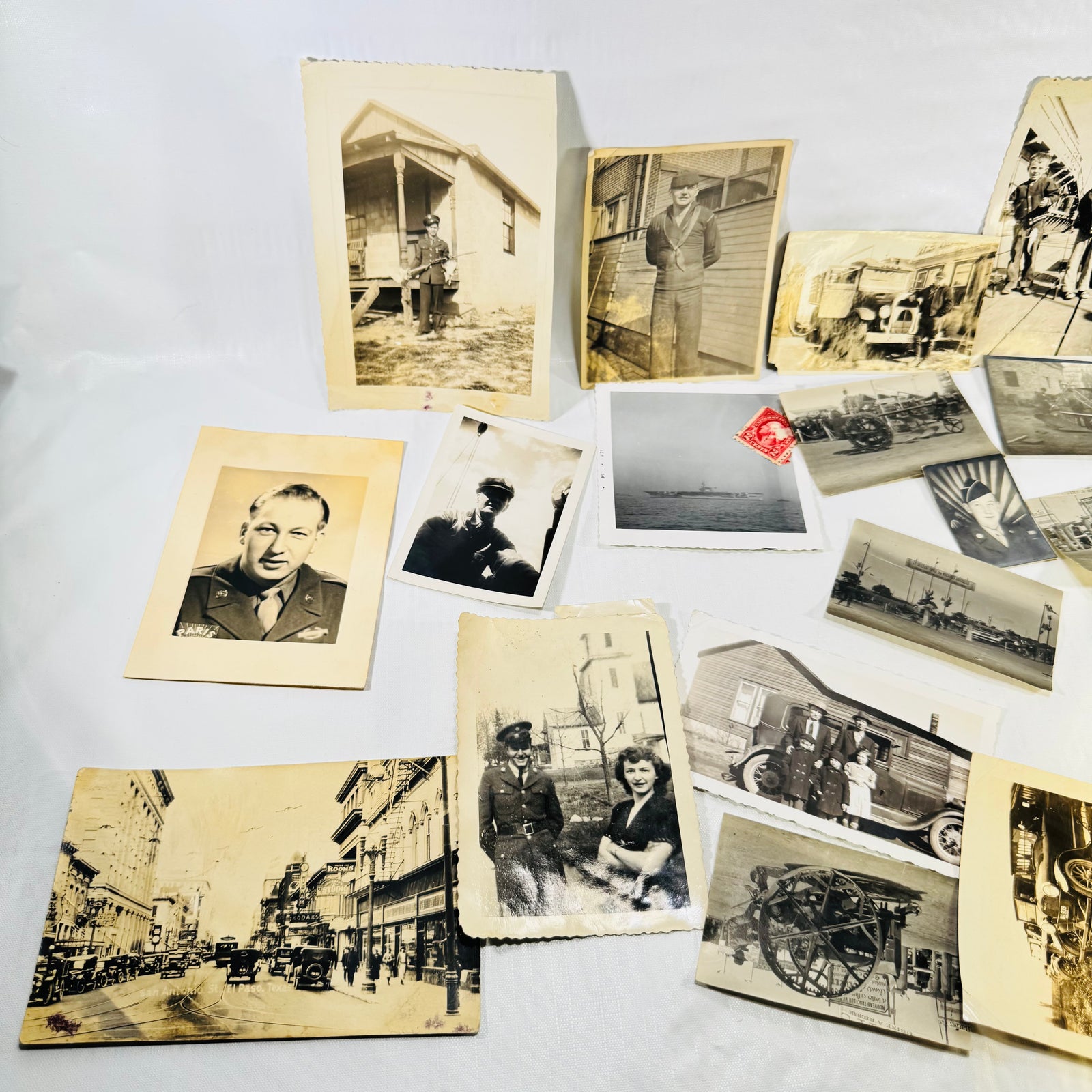 Close-up of vintage portrait snapshots and early automobiles in the photo lot
