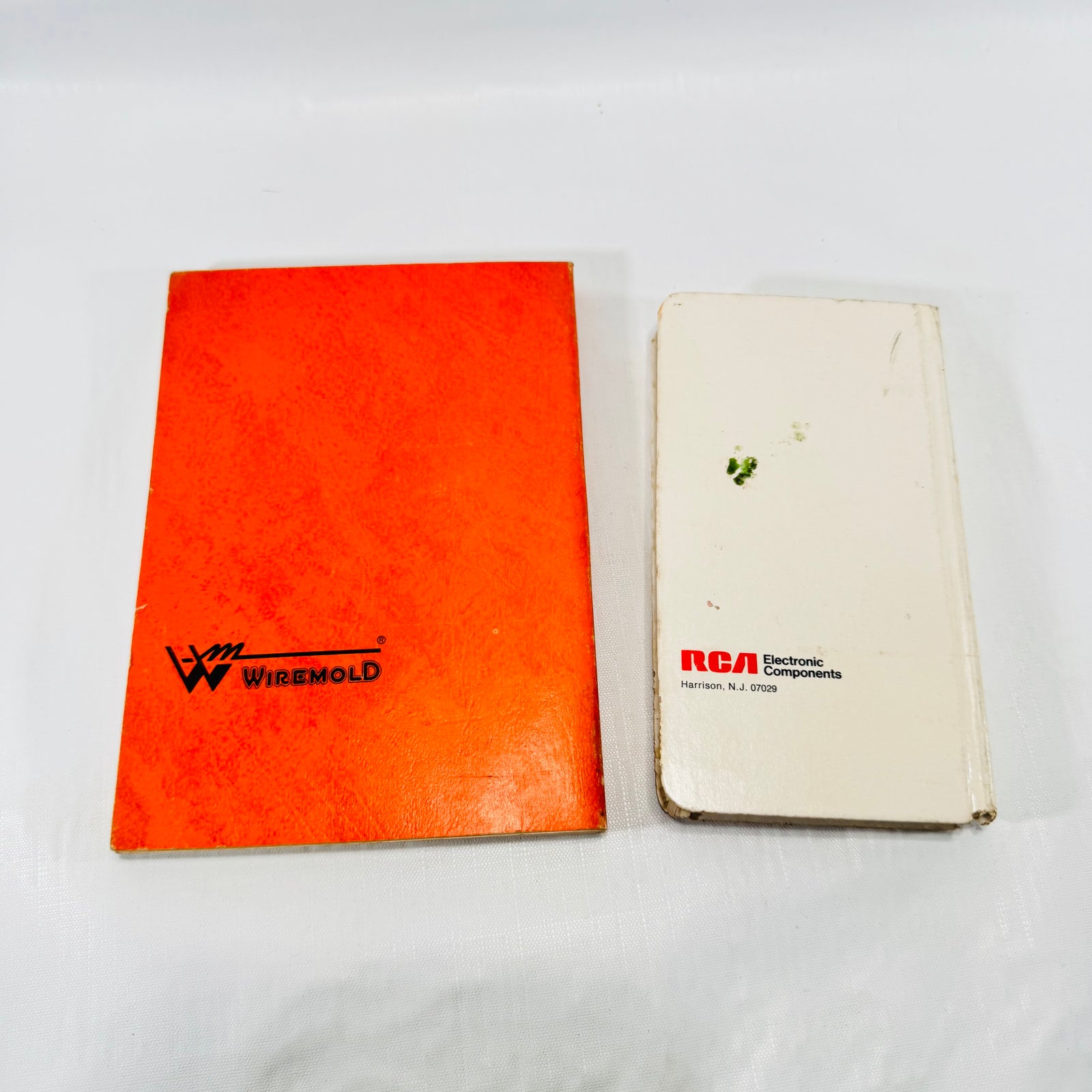 Back covers of the Wiremold catalog and RCA reference book, showing a green stain on the RCA back.