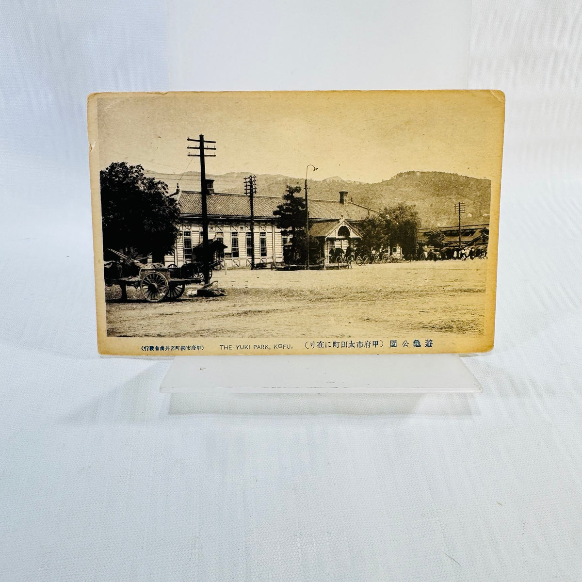 Sepia Yuki Park Kofu Japan postcard showing a building, wooden cart and mountain backdrop
